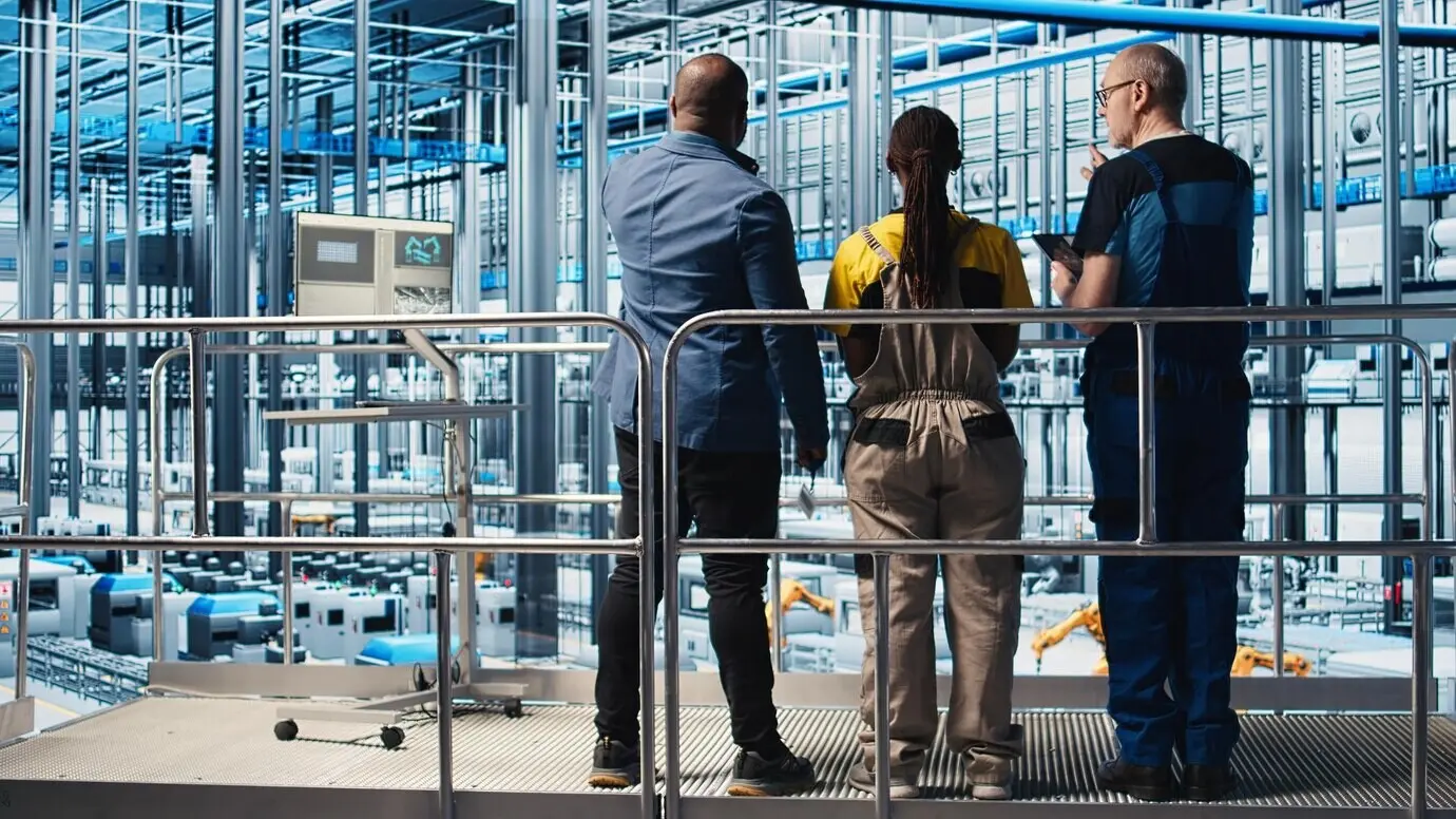 Gerente de planta fotovoltaica de Industria 4.0 en una plataforma industrial supervisando el trabajo realizado por ingenieros para