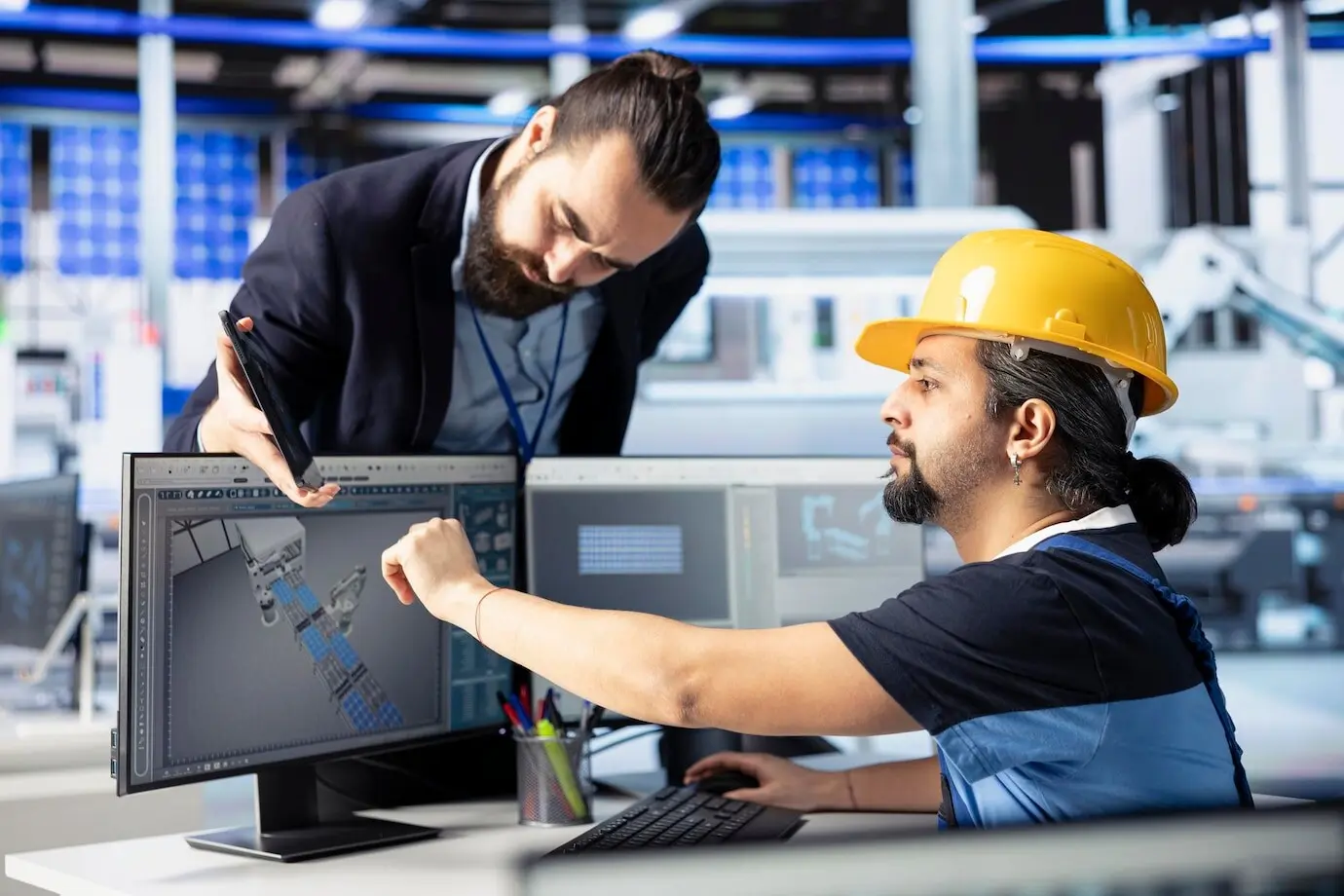 Líder de equipo supervisando el trabajo realizado por un hombre que desarrolla diseños de paneles solares.