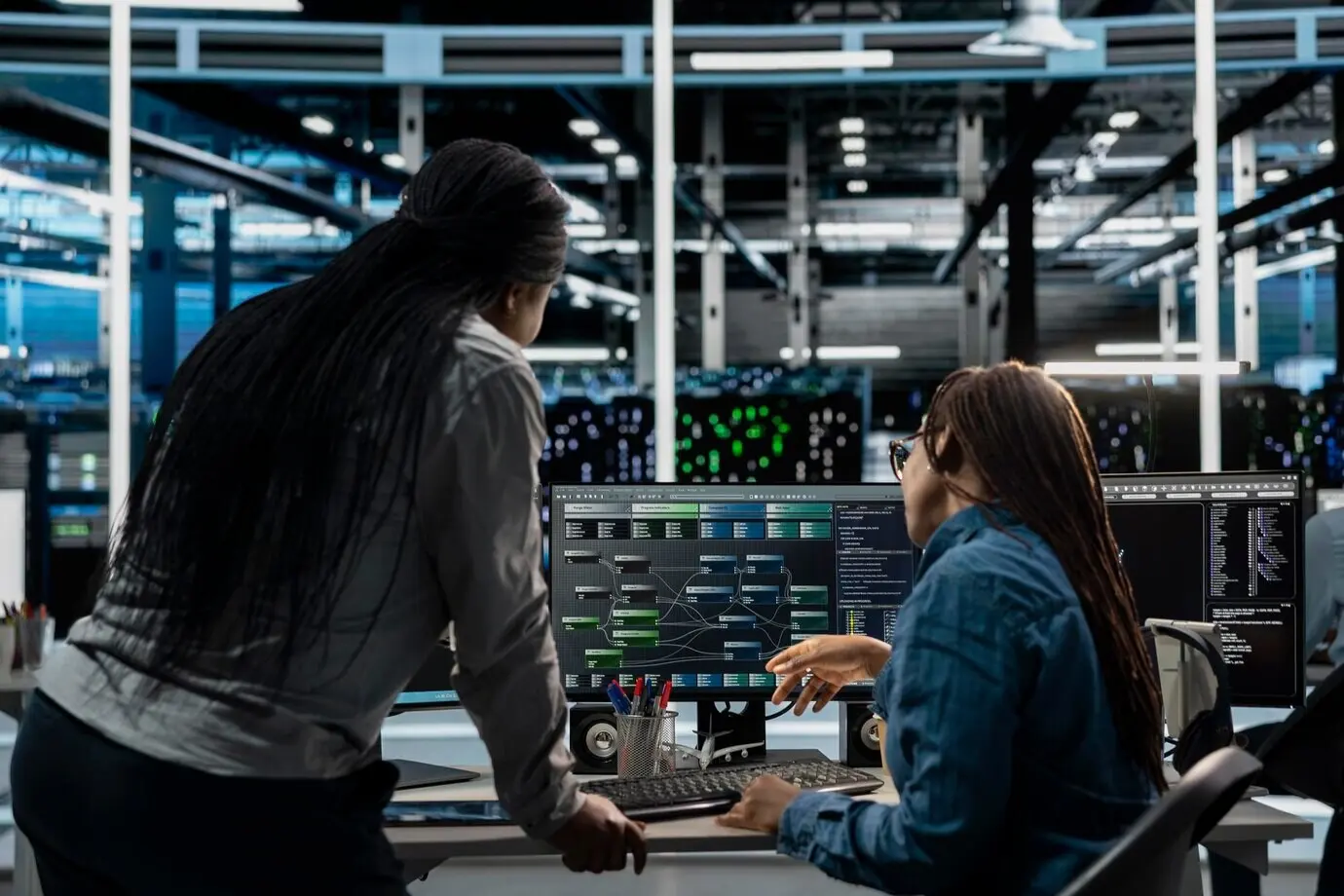 El gerente de la sala de servidores supervisa el trabajo realizado por un ingeniero que utiliza inteligencia artificial.